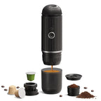 Black portable espresso machine with accessories on a white background