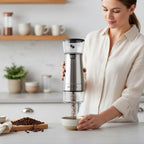 Woman using a manual coffee grinder in a kitchen setting
